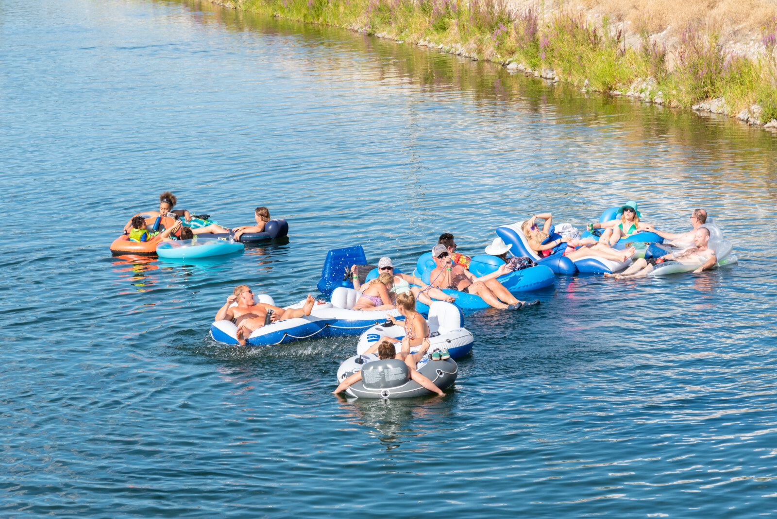 Penticton, British Columbia/Canada - September 1, 2019: a group of friends float down the Penticton River Channel together on a hot day, a popular summer activity.